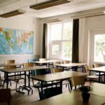 Desks and chairs arranged in classroom at high school